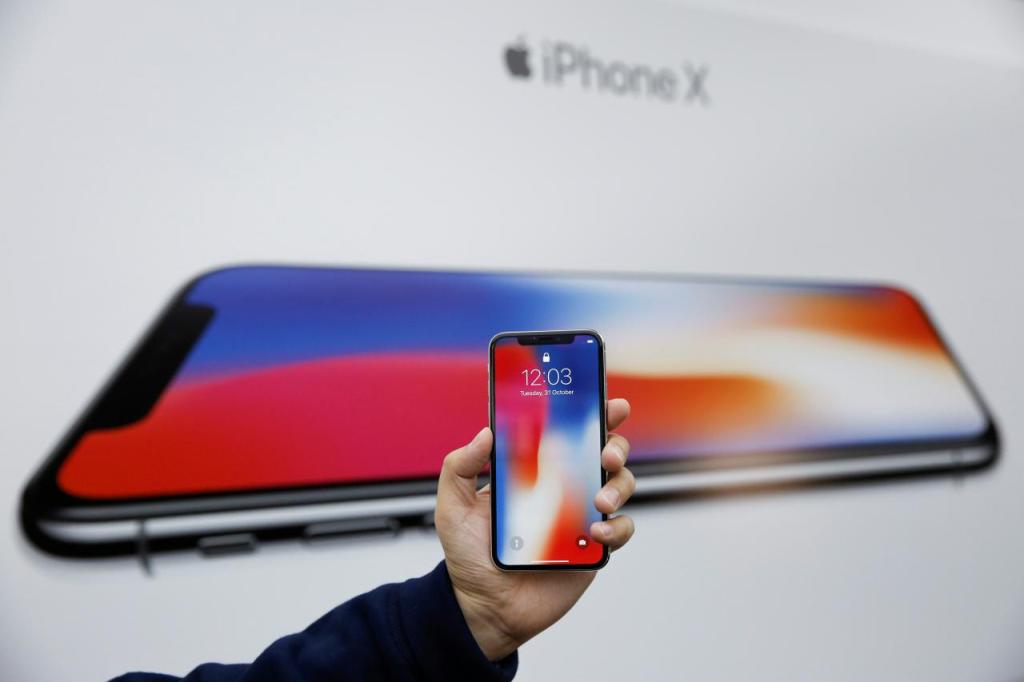 An attendee holds a new iPhone X during a presentation for the media in Beijing, China October 31, 2017. REUTERS/Thomas Peter
