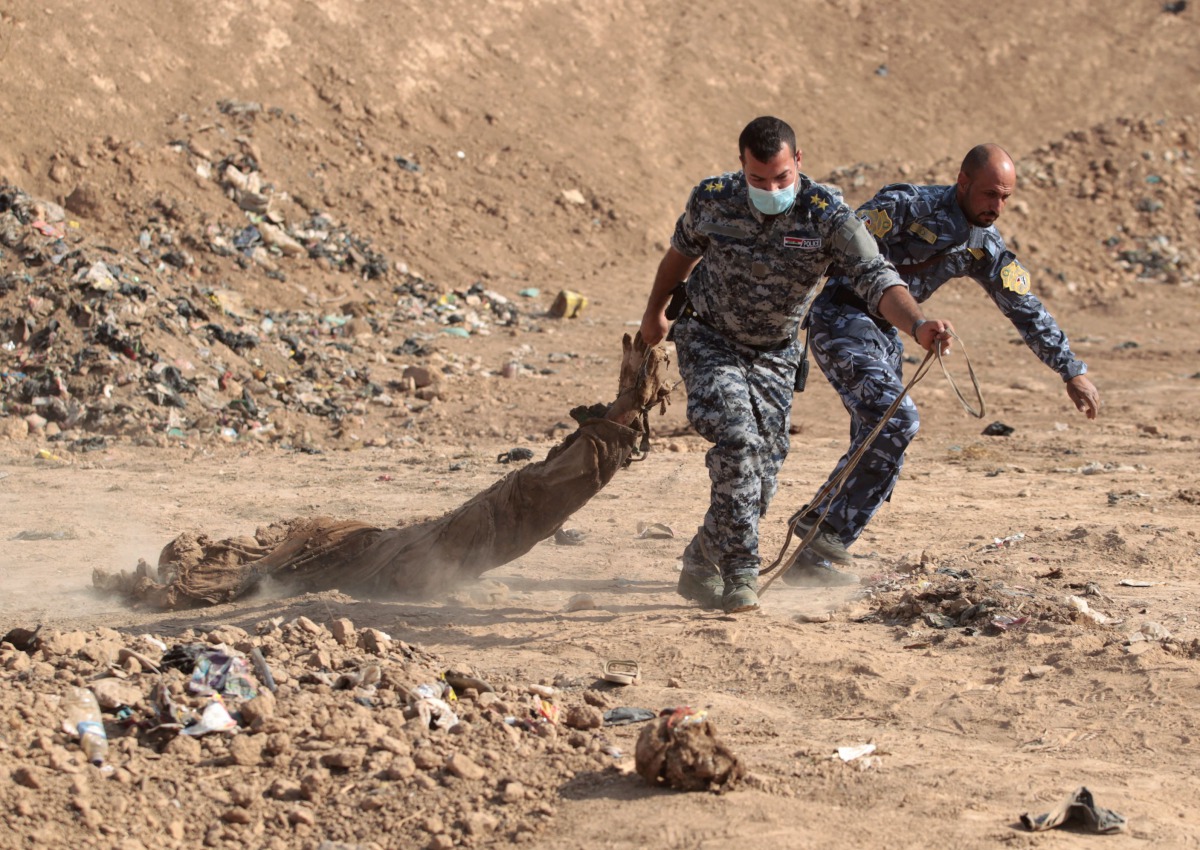 FILE PHOTO: Iraqi forces pull a body out from a mass grave they discovered in the Hamam al-Alil area on November 7, 2016. (AFP / Ahmad Al-Rubaye) 