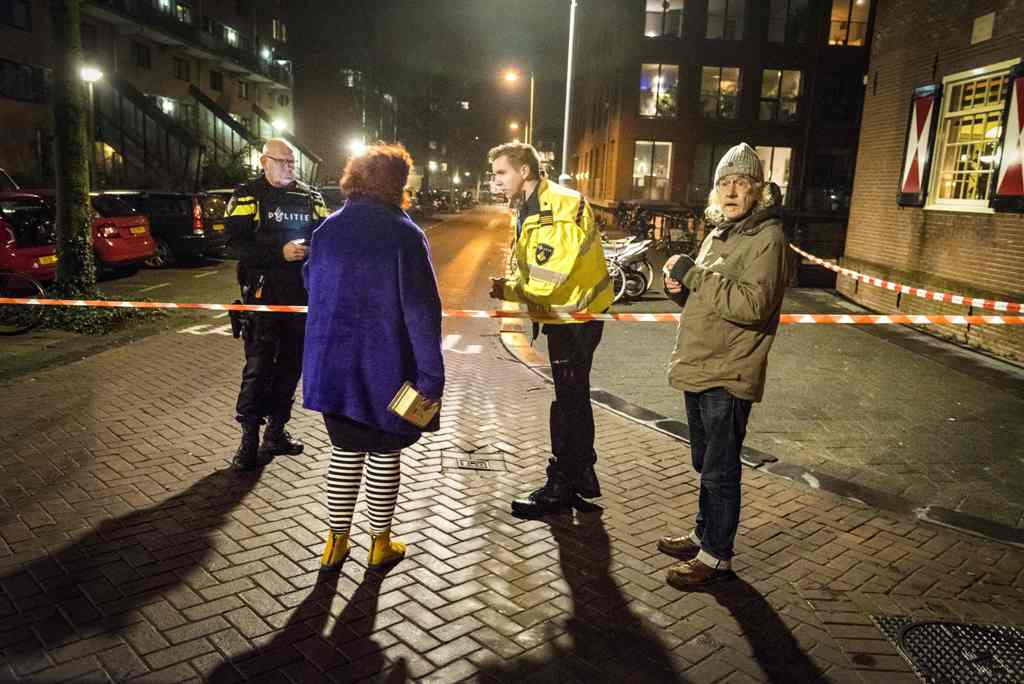 Policemen stand guard at a closed off lane following a shooting at the Grote Wittenburgstraat in Amsterdam on January 26, 2018.  AFP / ANP / Evert Elzinga
