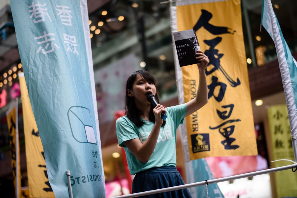 A file photo of pro-democracy Demosisto party member Agnes chow speaking to passing pedestrians in Hong Kong ahead of a candlelight vigil to mark the 28th anniversary of the June 4 Tiananmen crackdown in Beijing in 1989, June 4, 2017. / AFP / Anthony WALL