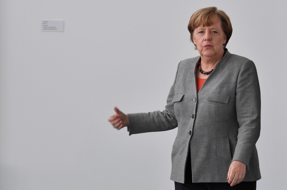 German Chancellor Angela Merkel walks out of her office to meet the President of the German Horticultural Association in the chancellery in Berlin, Germany, February 9, 2018. AFP / John MACDOUGALL