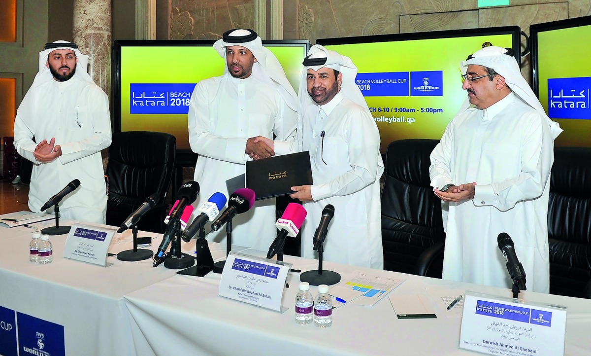 Qatar Volleyball Association  (QVA) President Ali Ghanim Al Kuwari (second left) and Katara Cultural Village Foundation General Manager and Katara Beach Volleyball Cup 2018 Tournament Director Dr Khalid bin Ibrahim Al Sulaiti exchanging documents during a