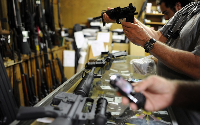 Customers look over the last two AR-15 style rifles for sale inside the Bullet Hole gun shop in Sarasota, Florida (Reuters) 