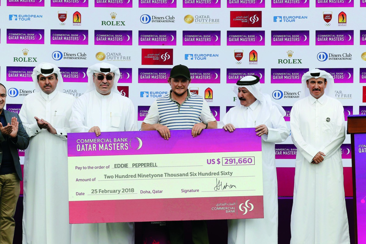Eddie Pepperell (centre) of England receiving the winner’s cheque from officials during the awards ceremony at the Commercial Bank Qatar Masters golf tournament at the Doha Golf Club in Doha, yesterday.