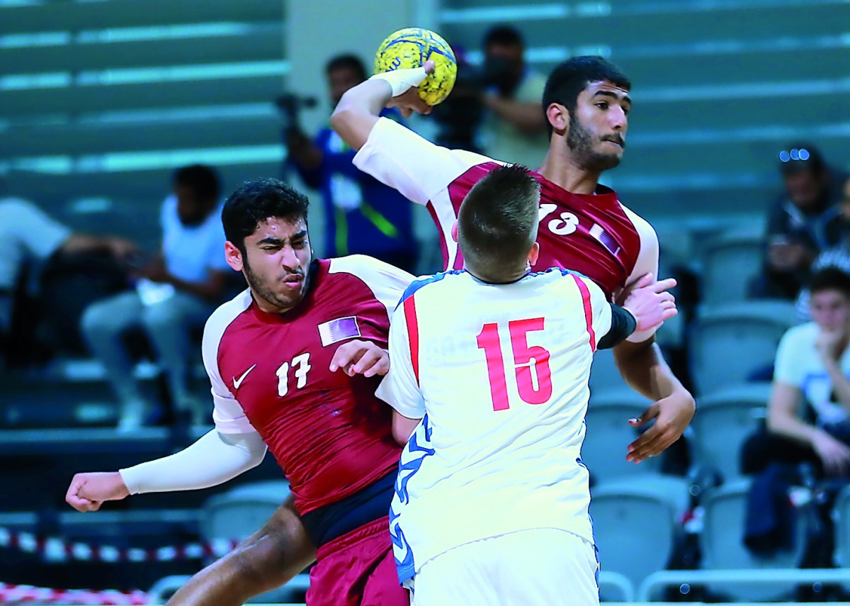 A Qatari player prepares to shoot while a Serbian player attempts to spoil his effort during their placement match  played at the Ali bin Hamad Al Attiyah Stadium in Al Sadd.  Qatar won 24-23.

