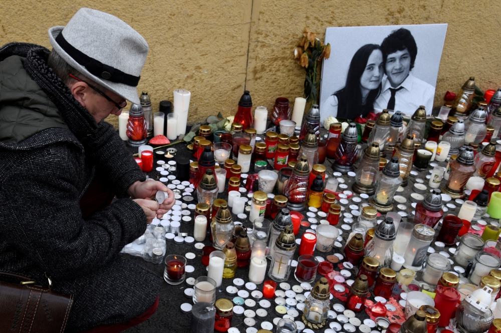 A man lights a candle for a tribute to murdered Slovak investigative reporter Jan Kuciak at Slovak National Uprising Square in Bratislava, Slovakia, February 27, 2018. REUTERS/Radovan Stoklasa