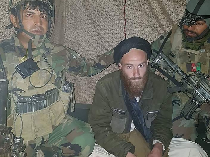 This handout picture released by the Afghan Armed Forces on February 28, 2018 shows a man (C) who identified himself as a German national after being arrested by Afghan commandos in Helmand province. AFP PHOTO / AFGHAN ARMED FORCES