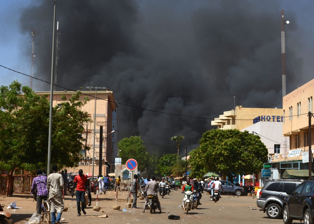 People watch as black smoke rises as the capital of Burkina Faso came under multiple attacks on March 2, 2018, targeting the French embassy, the French cultural centre and the country's military headquarters.  AFP / Ahmed Ouoba