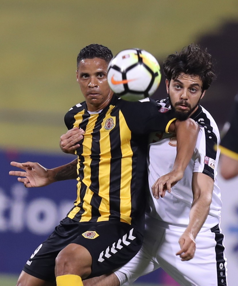 Qatar SC and Umm Salal players vie for ball possession during their QSL game yesterday.   