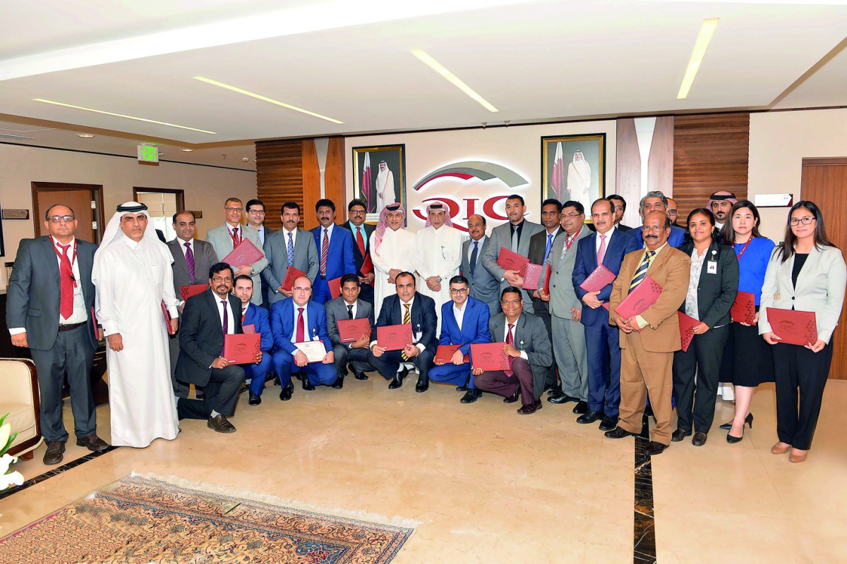 QIC officials with the employees during the event.
