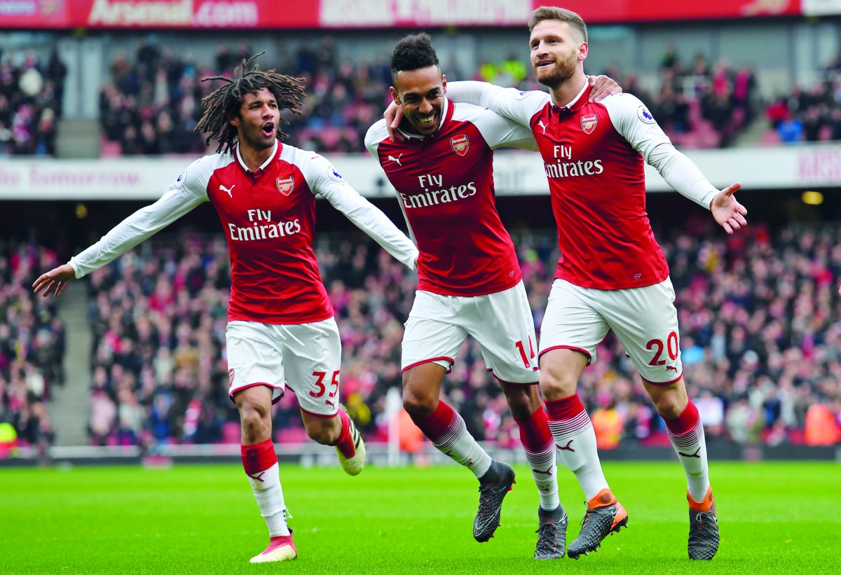 Arsenal's German defender Shkodran Mustafi (R) celebrates with Arsenal's Egyptian midfielder Mohamed Elneny (L) and Arsenal's Gabonese striker Pierre-Emerick Aubameyang (C) after scoring the opening goal of the English Premier League football match betwee