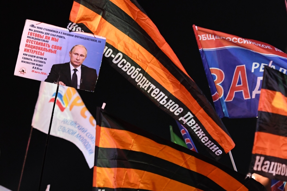 People attend a rally and a concert celebrating the fourth anniversary of Russia's annexation of Crimea at Manezhnaya Square in Moscow on March 18, 2018. AFP / Kirill Kudryavtsev