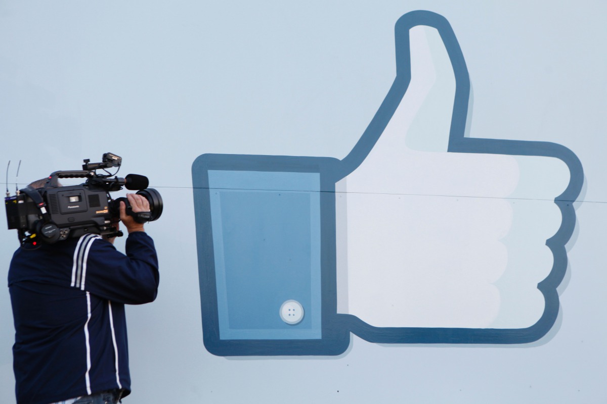 A videographer shooting the side of Facebook Like Button logo displayed at the entrance of the Facebook Headquarters in Menlo Park, California, May 18, 2012 (AFP) 