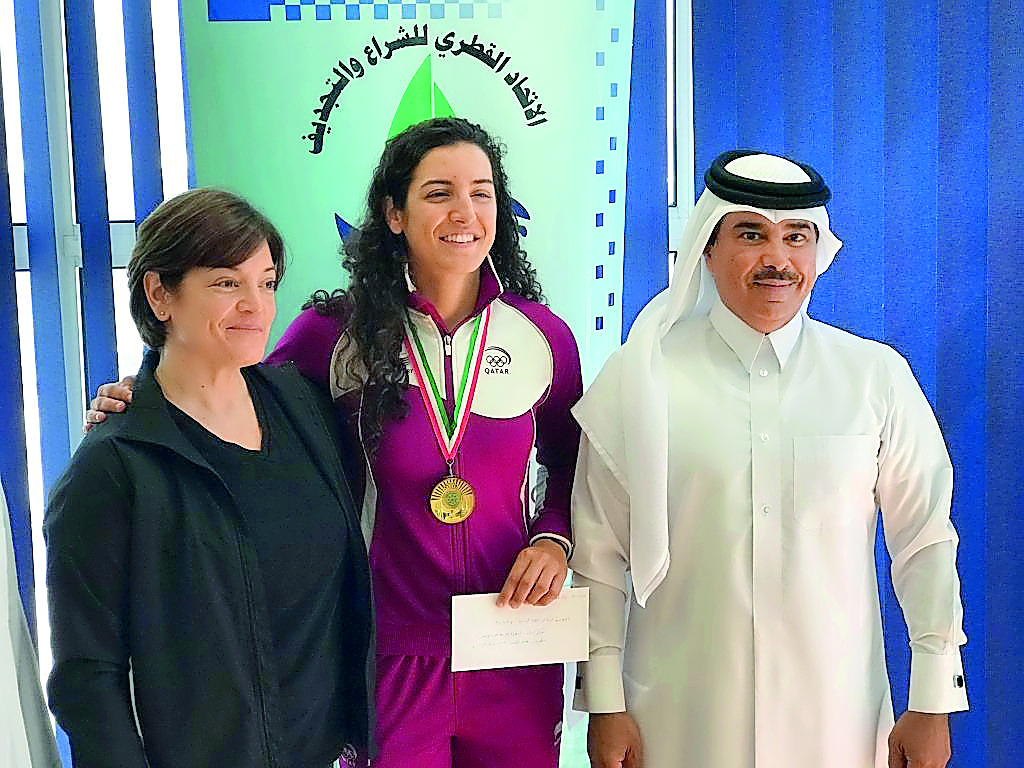 Gold medallist at the Arab Indoor Rowing Championship, Qatar’s rising star Tala Abu Jabara (centre) poses for a photograph with the President of Qatar Sailing and Kayaking Federation (QSKF), Abdullah Al Sulaiti (right) during a welcoming ceremony at the Q