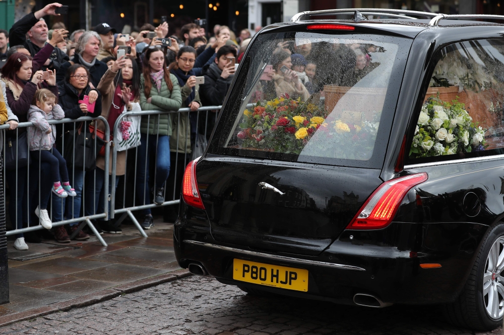 Well-wishers look at the coffin of British scientist Stephen Hawking inside the hearse after the funeral service at the Church of St Mary the Great, in Cambridge on March 31, 2018. AFP / Daniel Leal-Olivas