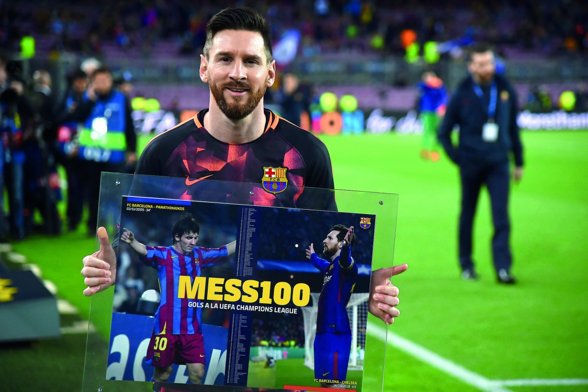 Barcelona's Argentinian forward Lionel Messi holds a framed poster celebrating his 100th Champions League goal ahead of the UEFA Champions League quarter-final first leg football match between Barcelona and AS Roma at the Camp Nou Stadium in Barcelona on 