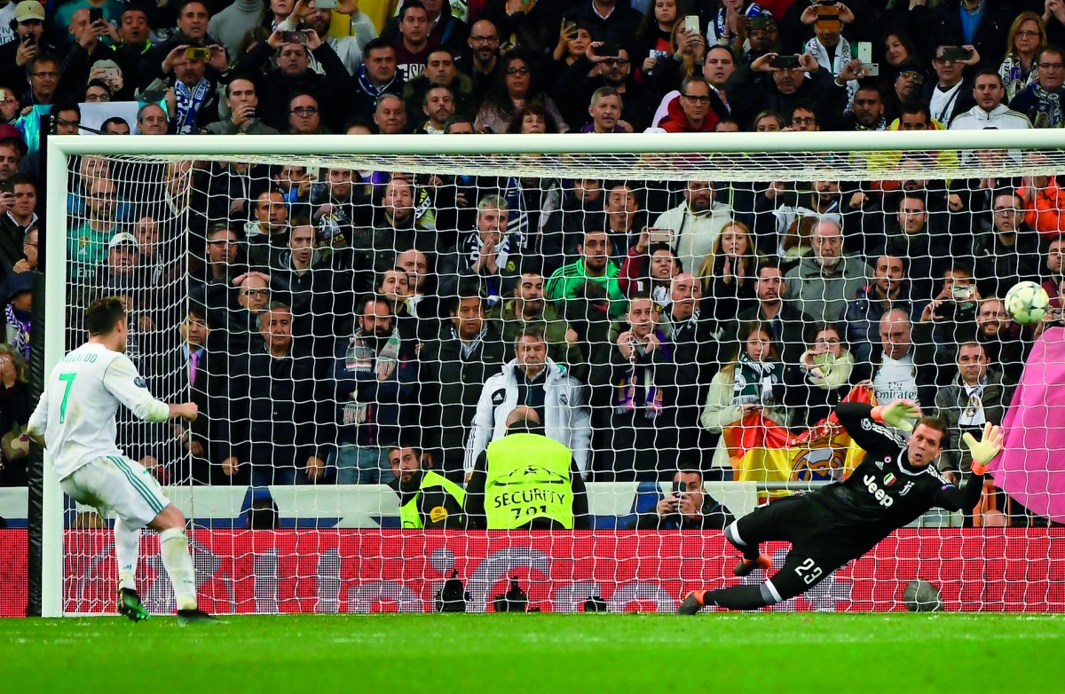 Real Madrid's Portuguese forward Cristiano Ronaldo shoots a penalty kick to score a goal during the UEFA Champions League quarter-final second leg football match between Real Madrid CF and Juventus FC at the Santiago Bernabeu stadium in Madrid on April 11