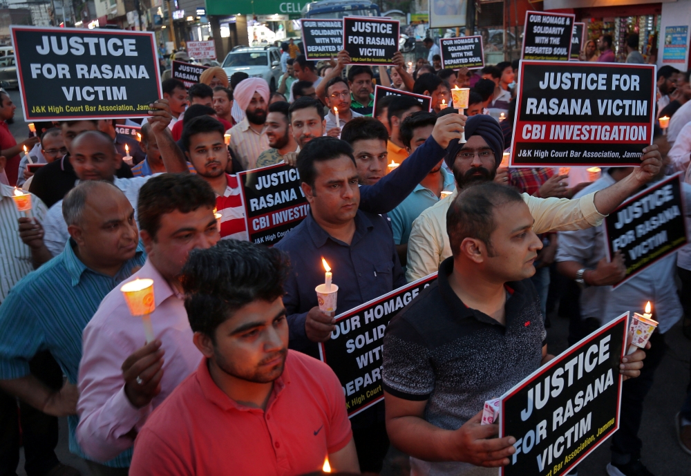 People hold candles and placards during a vigil, organised by the members of the Jammu and Kashmir High Court Bar Association, to show solidarity with the victim and demand a Central Bureau of Investigation (CBI) probe into the rape and murder of an eight