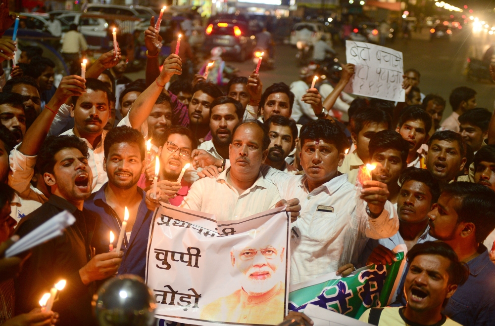 File photo of Indian Congress workers participate in a candle light procession as they shout slogans against Indian Prime Minister Narendra Modi during a protest against rape incidents, in Allahabad, April 13, 2018. / AFP / SANJAY KANOJIA 