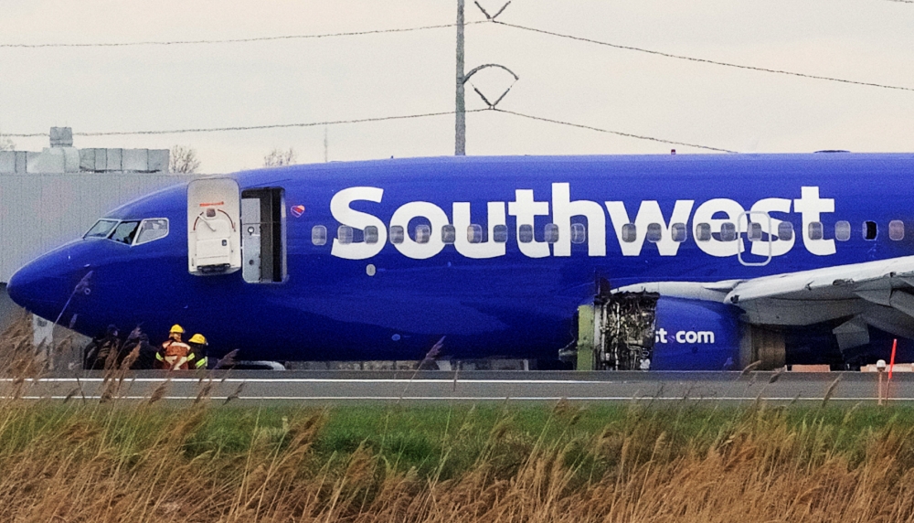 Emergency personnel monitor the damaged engine of Southwest Airlines Flight 1380, which diverted to the Philadelphia International Airport after the airline crew reported damage to one of the aircraft's engines, on a runway in Philadelphia, Pennsylvania U