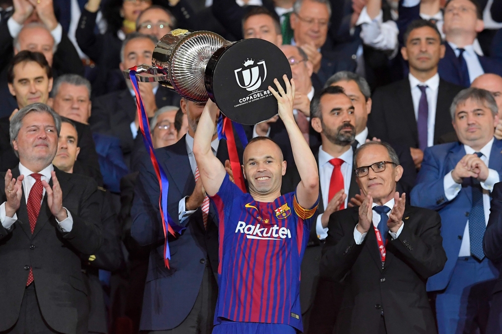 Barcelona's Spanish midfielder Andres Iniesta (C) holds the trophy after the Spanish Copa del Rey (King's Cup) final football match Sevilla FC against FC Barcelona at the Wanda Metropolitano stadium in Madrid on April 21, 2018. Barcelona won 5-0. / AFP / 