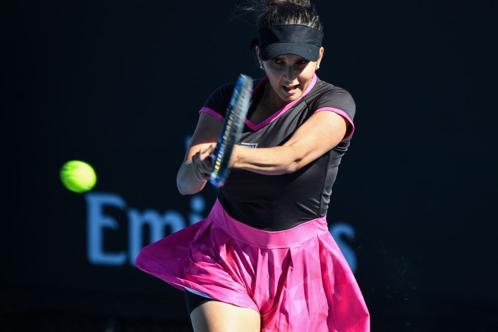 In this file photo taken on January 21, 2017, India's Sania Mirza hits a return against Germany's Laura Siegemund and Croatia's Mate Pavic during their mixed doubles first round match on day six of the Australian Open tennis tournament in Melbourne.  AFP 