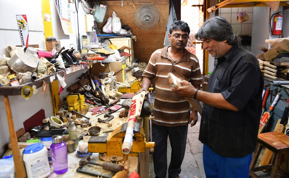 Indian bat maker Aslam Chaudhry inspecting a cricket bat at his workshop in Mumbai. (AFP / Indranil Mukherjee)