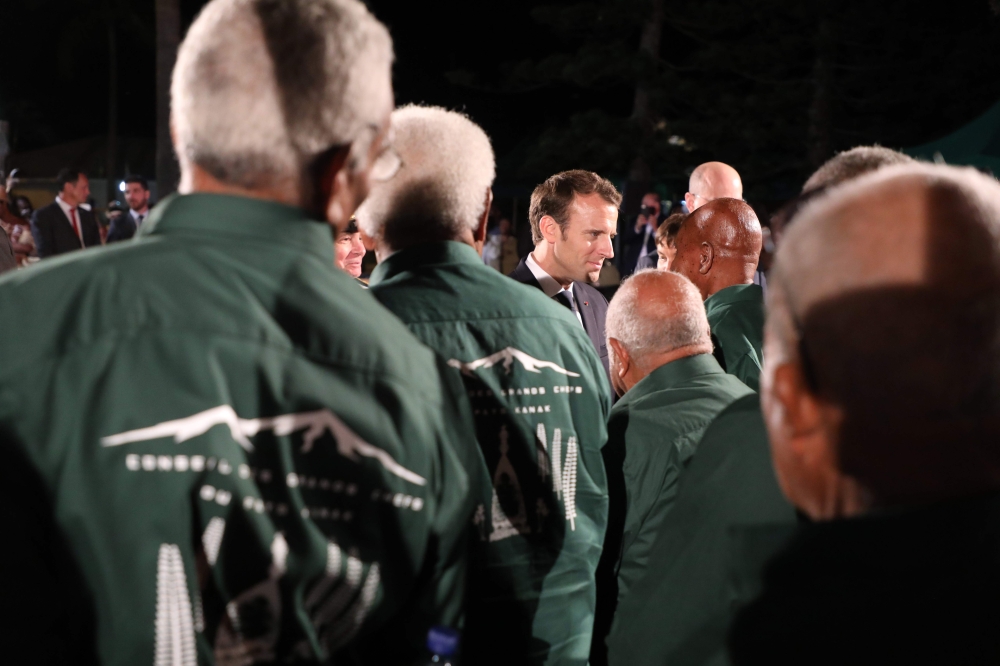 French President Emmanuel Macron (C) speaks with attendees during a ceremony in Noumea on May 3, 2018. AFP / Ludovic Marin 