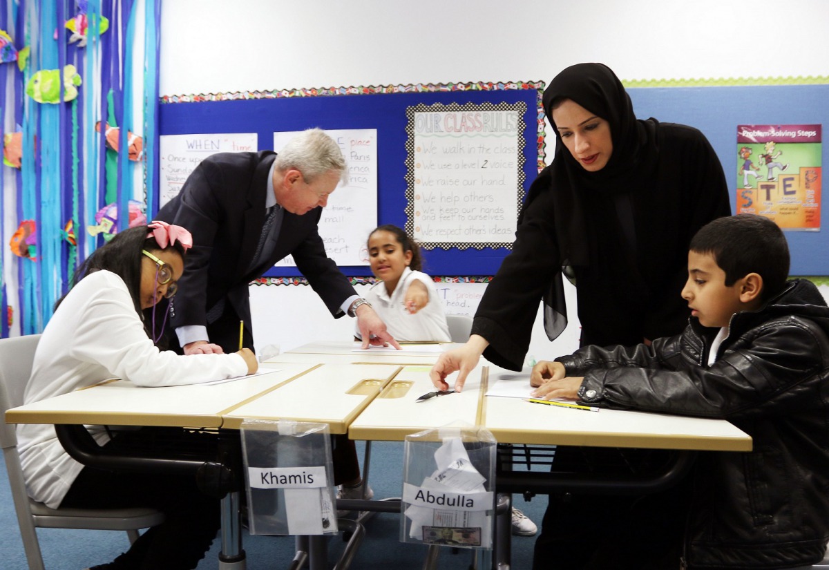 Buthaina Ali Al Nuaimi, President, PUE, QF, and Bernard Dunn, President, Boeing Middle East, North Africa and Turkey, with children taking part in the Curiosity Machine program. 
