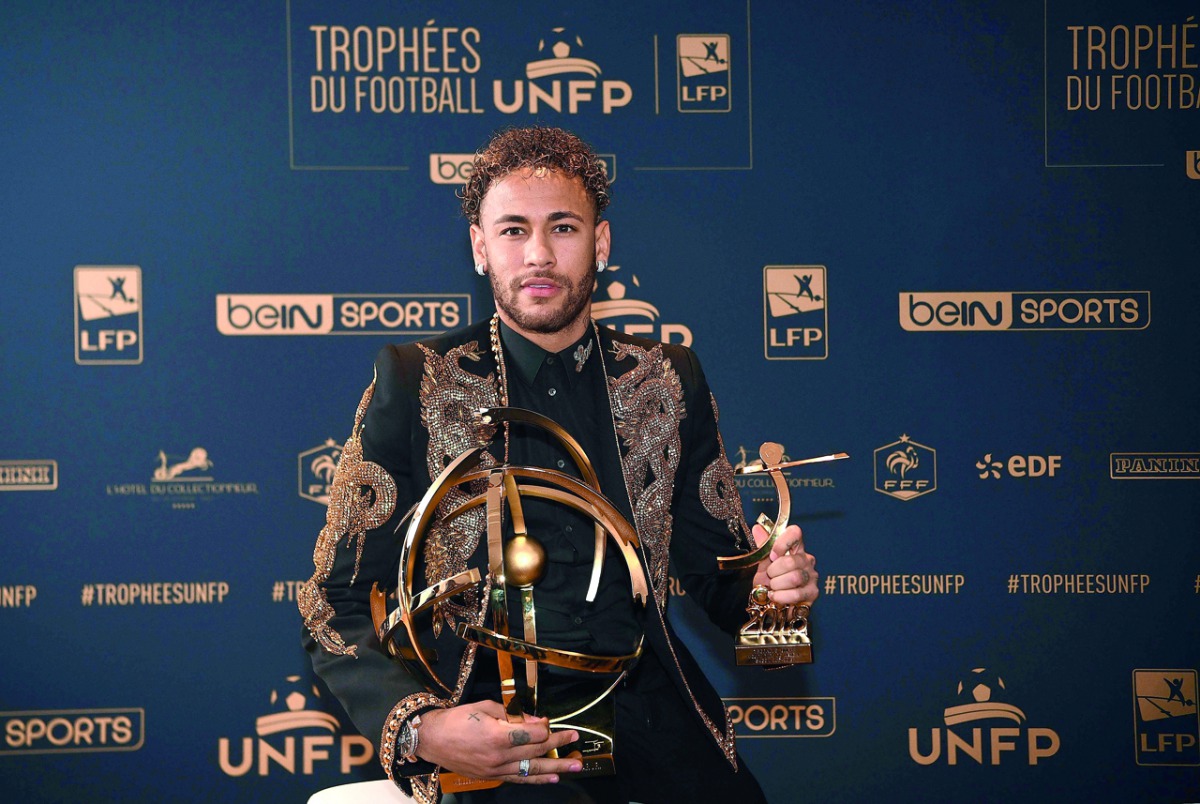Paris Saint-Germain's Brazilian forward Neymar poses with his trophy after receiving the Best Ligue 1 Player award during a TV show on May 13, 2018 in Paris, as part of the 27th edition of the UNFP (French National Professional Football players Union) tro