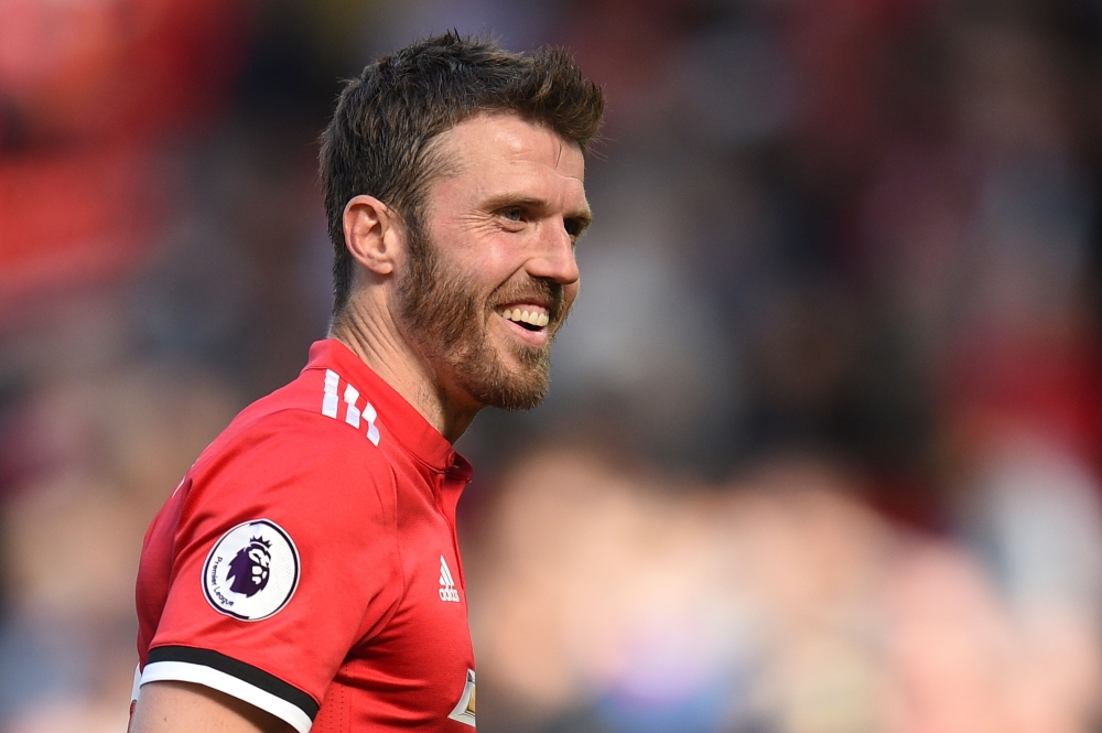 Manchester United's English midfielder Michael Carrick shares a joke at the end of the English Premier League football match between Manchester United and Watford at Old Trafford in Manchester, north west England, on May 13, 2018. AFP / Oli Scarff 
