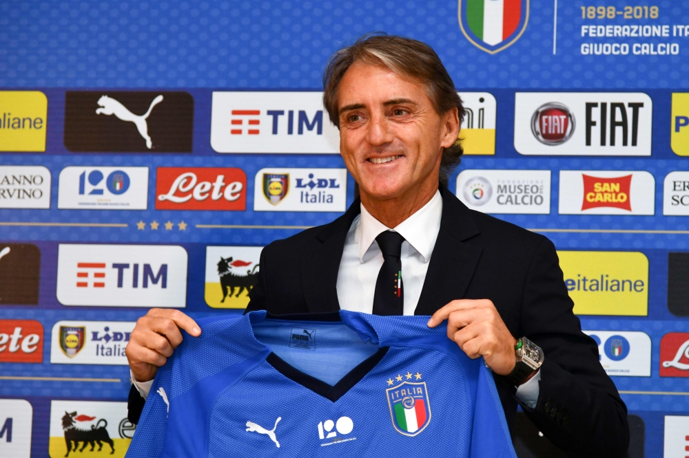 Italy's national football team newly appointed head coach, Roberto Mancini holds Italy's jersey during a press conference on May 15, 2018 at the national team's training centre at Coverciano near Florence.  AFP / Carlo BRESSAN
