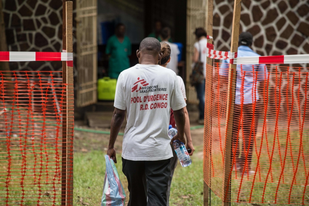 Doctors Without Borders (Medecins sans frontiere - MSF) team members walk through an Ebola security zone at the entrance of the Wangata Reference Hospital in Mbandaka, northwest of DR Congo on May 20, 2018. AFP / JUNIOR KANNAH