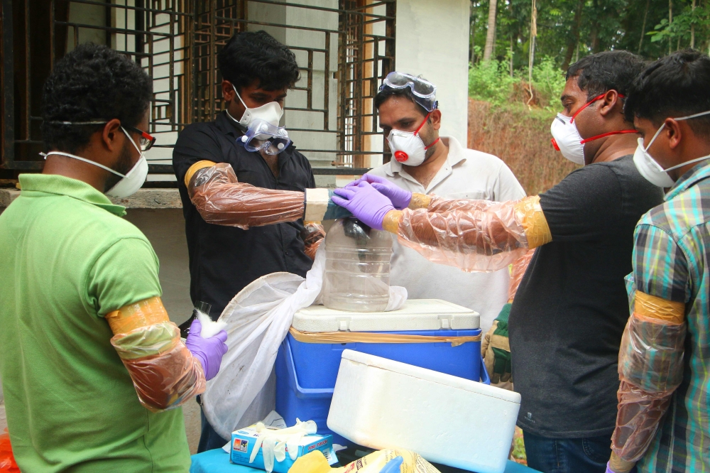 Animal Husbandry department and Forest officials deposit a bat into a container after catching it inside a well at Changaroth in Kozhikode in the Indian state of Kerala on May 21, 2018. A deadly virus carried mainly by fruit bats has killed at least three