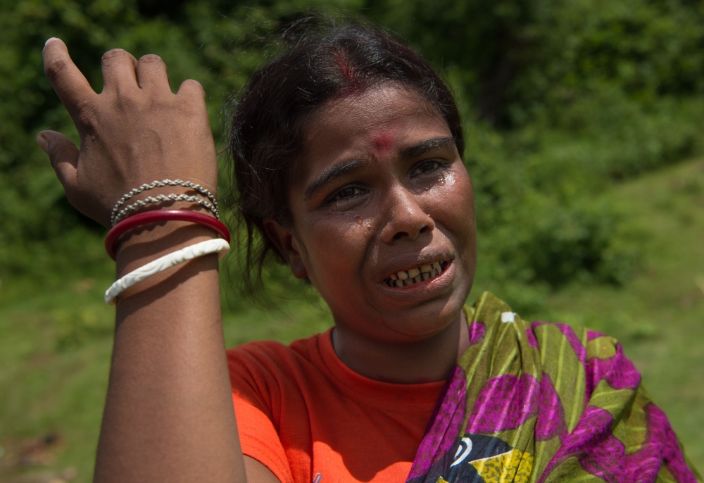 (FILES) In this file photo taken on September 27, 2017, a Hindu woman who lost four family members, cries near the dead bodies in Ye Baw Kyaw village, Maungdaw in Myanmar's northern Rakhine state. AFP / STR /