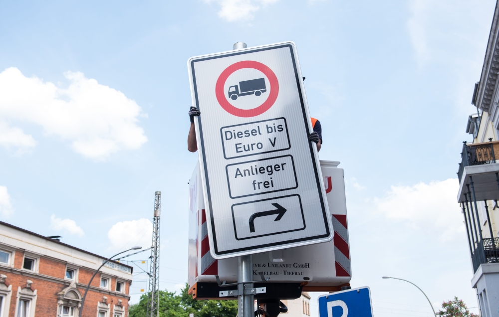 Picture taken on May 15, 2018 shows a worker fixing a driving ban sign for diesel trucks in Hamburg, northern Germany. From May 31, 2018, the city of Hamburg will ban some diesel vehicles from two major arteries to improve air quality, making the German p