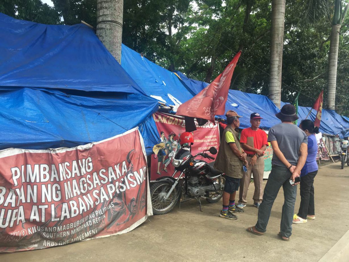 Activists and farmers demanding land stand at their camp outside the provincial agriculture office in Tagum City, Philippines. March 21, 2018. Thomson Reuters Foundation/Rina Chandran