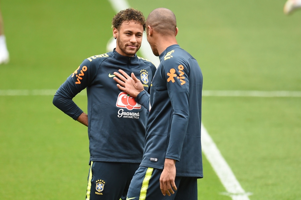 Brazil's striker Neymar (L) and Brazil's defender Miranda chat during a training session at Anfield stadium in Liverpool on June 2, 2018, ahead their International friendly football match against Croatia. / AFP / Oli SCARFF