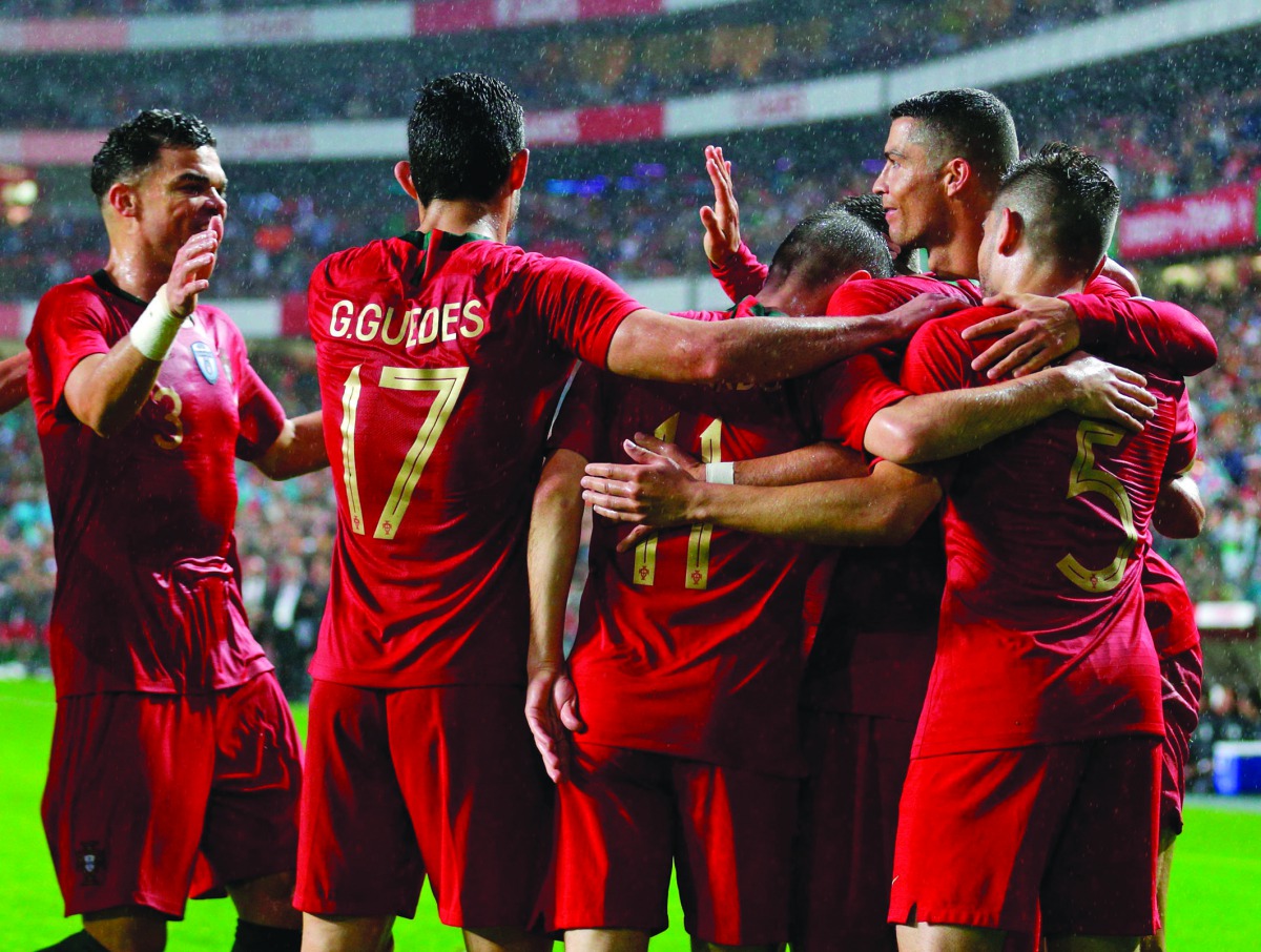 Portuguese forward Goncalo Guedes (2L) celebrates with teammates defender Pepe (L) and forward Cristiano Ronaldo (R) after scoring a goal during the friendly football match between Portugal and Algeria, on June 7, 2018 at the Luz stadium in Lisbon. AFP / 