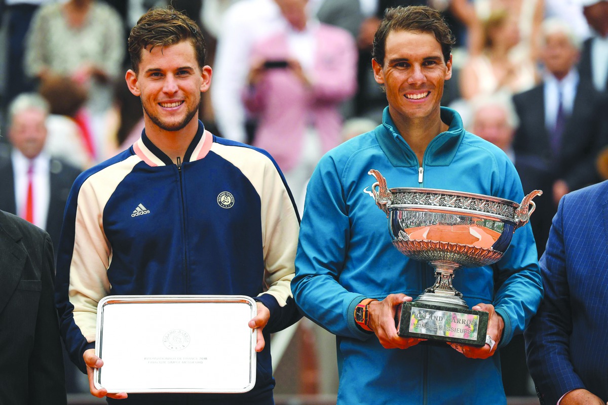 Spain's Rafael Nadal (R) poses with the Mousquetaires Cup (The Musketeers) after his victory, next to second placed Austria's Dominic Thiem, after their men's singles final match, on day fifteen of The Roland Garros 2018 French Open tennis tournament in P