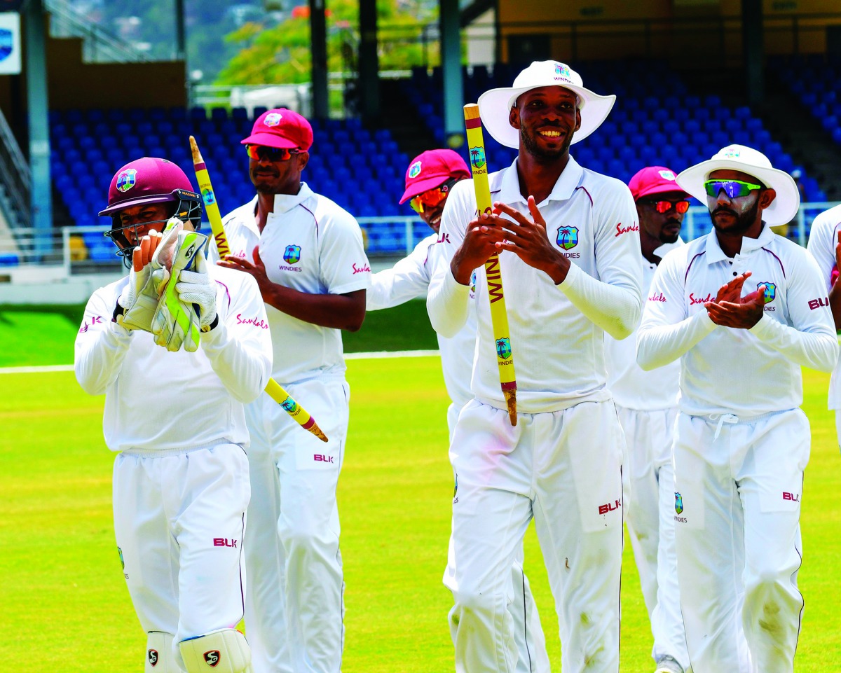 Shane Dowrich (L), Shannon Gabriel (2L), Roston Chase (2R) and Devendra Bishoo (R) of West Indies celebrate winning on day 5 of the 1st Test between West Indies and Sri Lanka at Queen's Park Oval, Port of Spain, Trinidad, on June 10, 2018. / AFP / Randy B