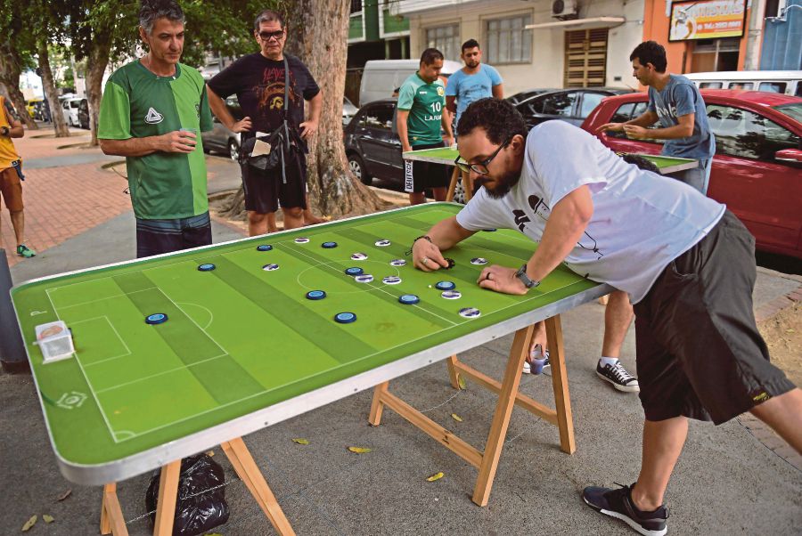 Every weekend, some 20 to 30 players meet in Rio de Janeiro to play with their customised colourful buttons, inspired in teams around the world and in legendary players. AFP
