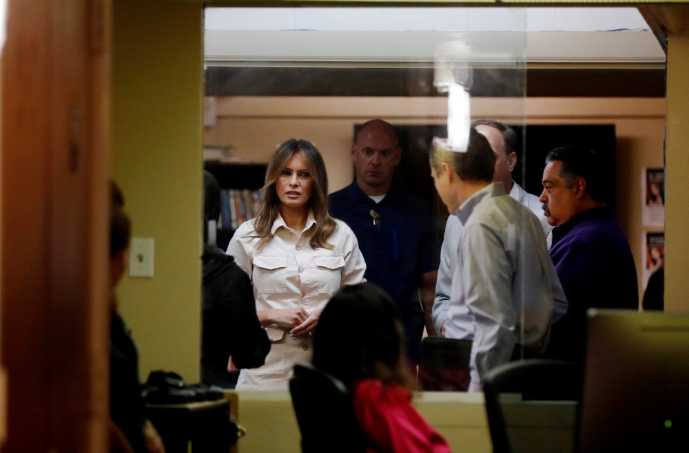 US first lady Melania Trump talks to staff and officials as she visits the Lutheran Social Services of the South 