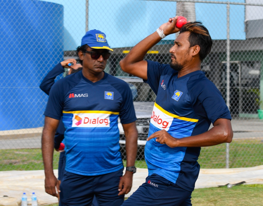 Suranga Lakmal (R) of Sri Lanka takes part in a training session under the watchful eye of Rumesh Ratnayake (L) one day before the 3rd Test between West Indies and Sri Lanka at Kensington Oval, Bridgetown, Barbados, on June 22, 2018. / AFP / Randy Brooks