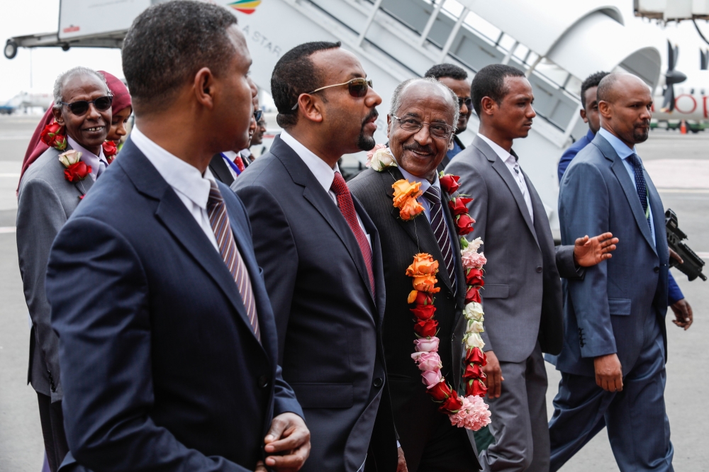 Eritrea's Foreign minister Osman Saleh Mohammed (3rdR) walks with Ethiopia's Prime Minister Abiy Ahmed (C) as Eritrea's delegation arrives for peace talks with Ethiopia at the international airport in Addis Ababa, Ethiopia, on June 26, 2018. / AFP / YONAS