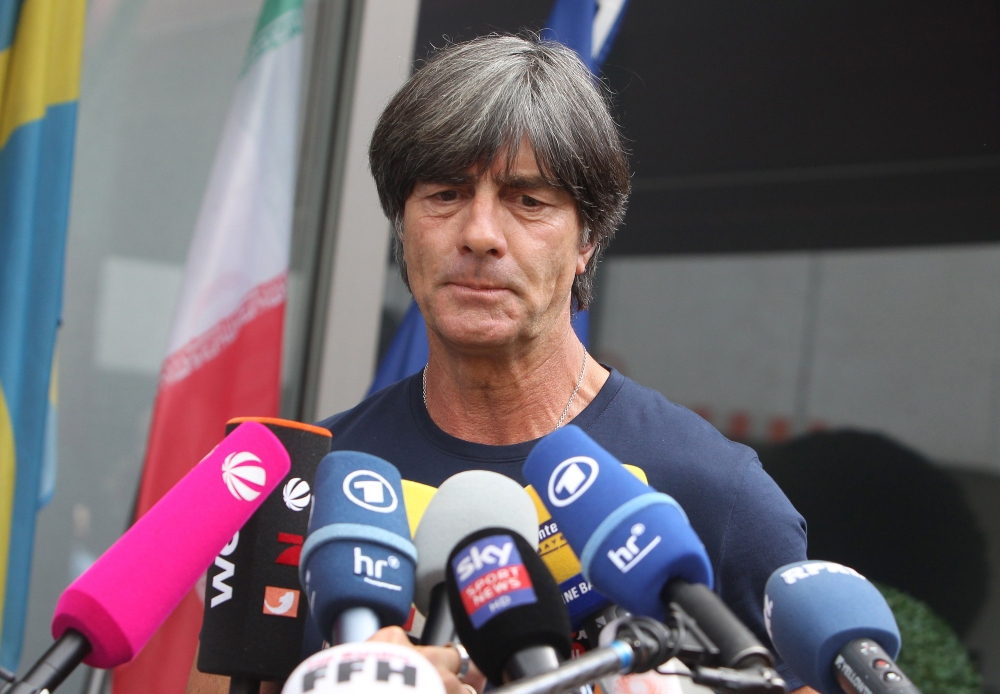 Germany's head coach Joachim Loew talks to media as he arrives at Frankfurt international airport on June 28, 2018, after flying back from Moscow following the German national football team's defeat in the Russia 2018 football World Cup. (AFP / Daniel ROL