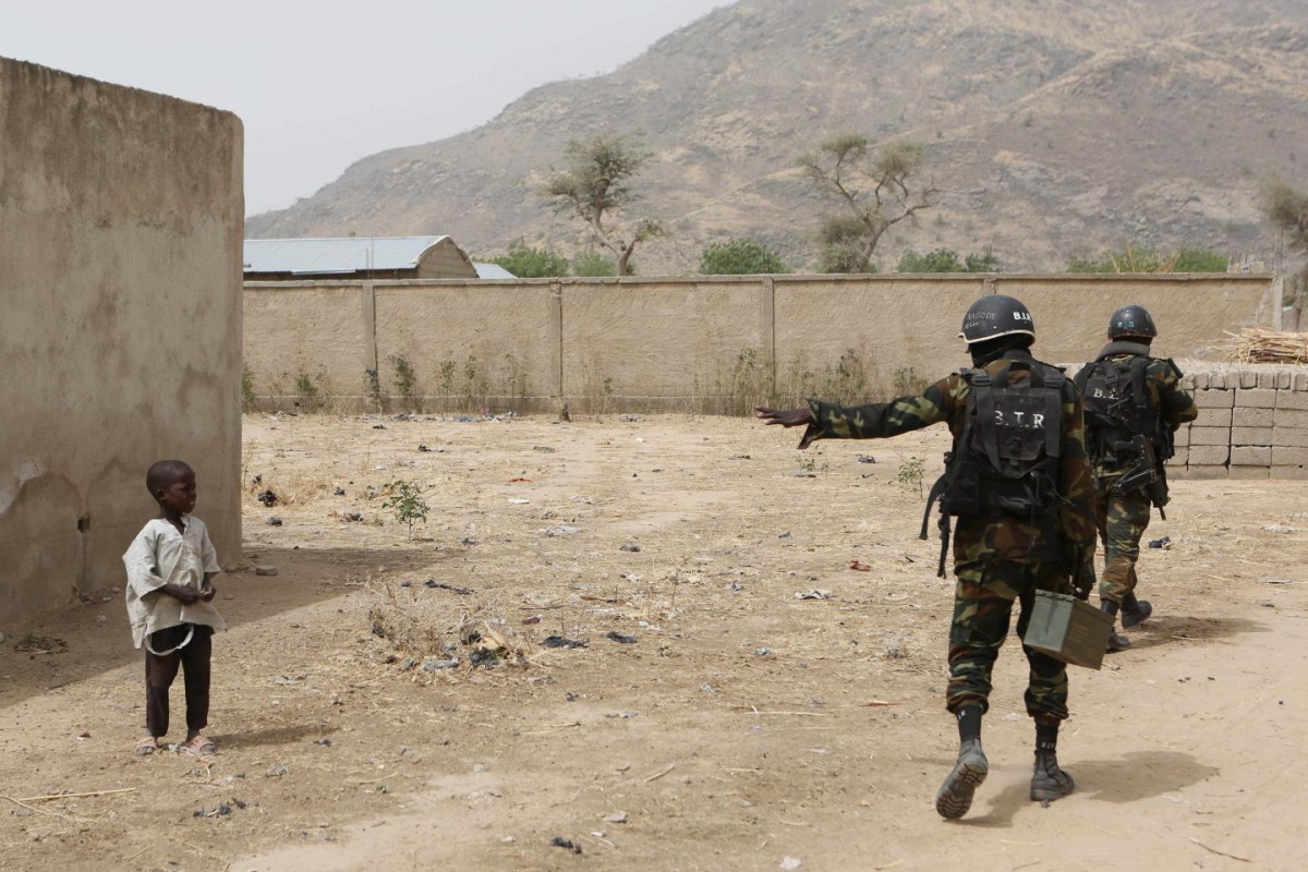 FILE PHOTO: Cameroonian soldiers from the Rapid Intervention Brigade tell a young boy to stay back while on patrol in Kerawa, Cameroon, March 16, 2016. Joe Penney/Reuters 