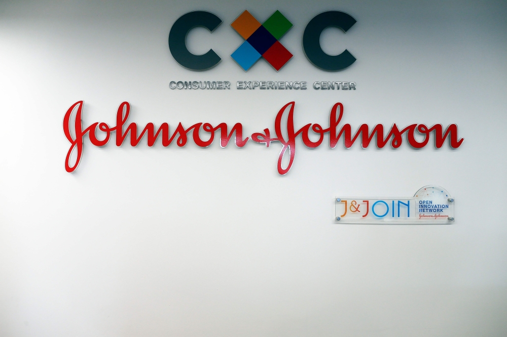 The logo of US multinational medical devices and pharmaceutical company Johnson & Johnson at the entrance of the research and development plant, in Val-de-Reuil, northwestern France on November 30, 2017. AFP / Charly Triballeau