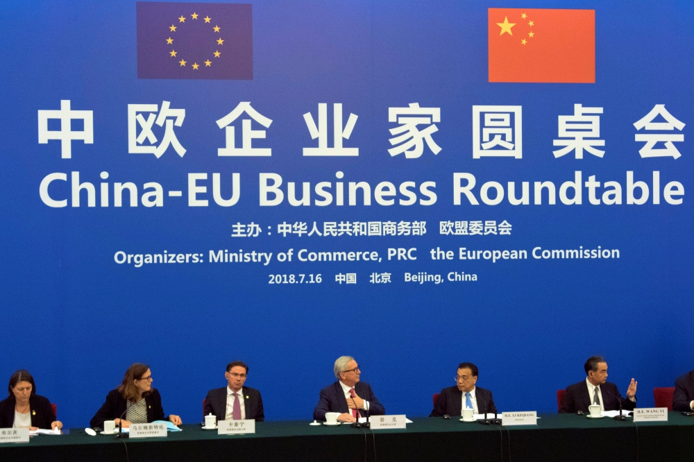 Chinese Premier Li Keqiang, center right, looks over to European Commission President Jean-Claude Juncker, center left, as they attend the China-EU Business Roundtable held at the Great Hall of the People in Beijing, China, Monday, July 16, 2018. Ng Han G