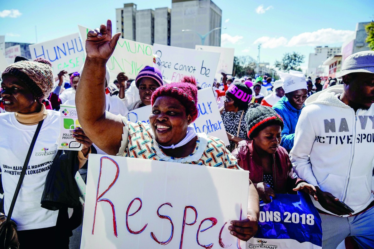 A demonstrator holds a placard on July 19, 2018 as she takes part in a march for peace organised by Churches Convergence on Peace Project, ahead of the Zimbabwe elections in Bulawayo, Zimbabwe. AFP / Zinyange Auntony